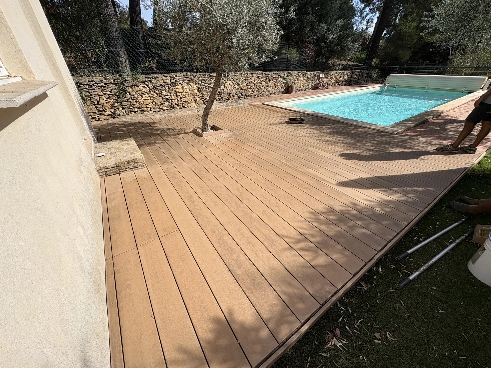 Plage de piscine en bois au pied d'un olivier, avant rénovation
