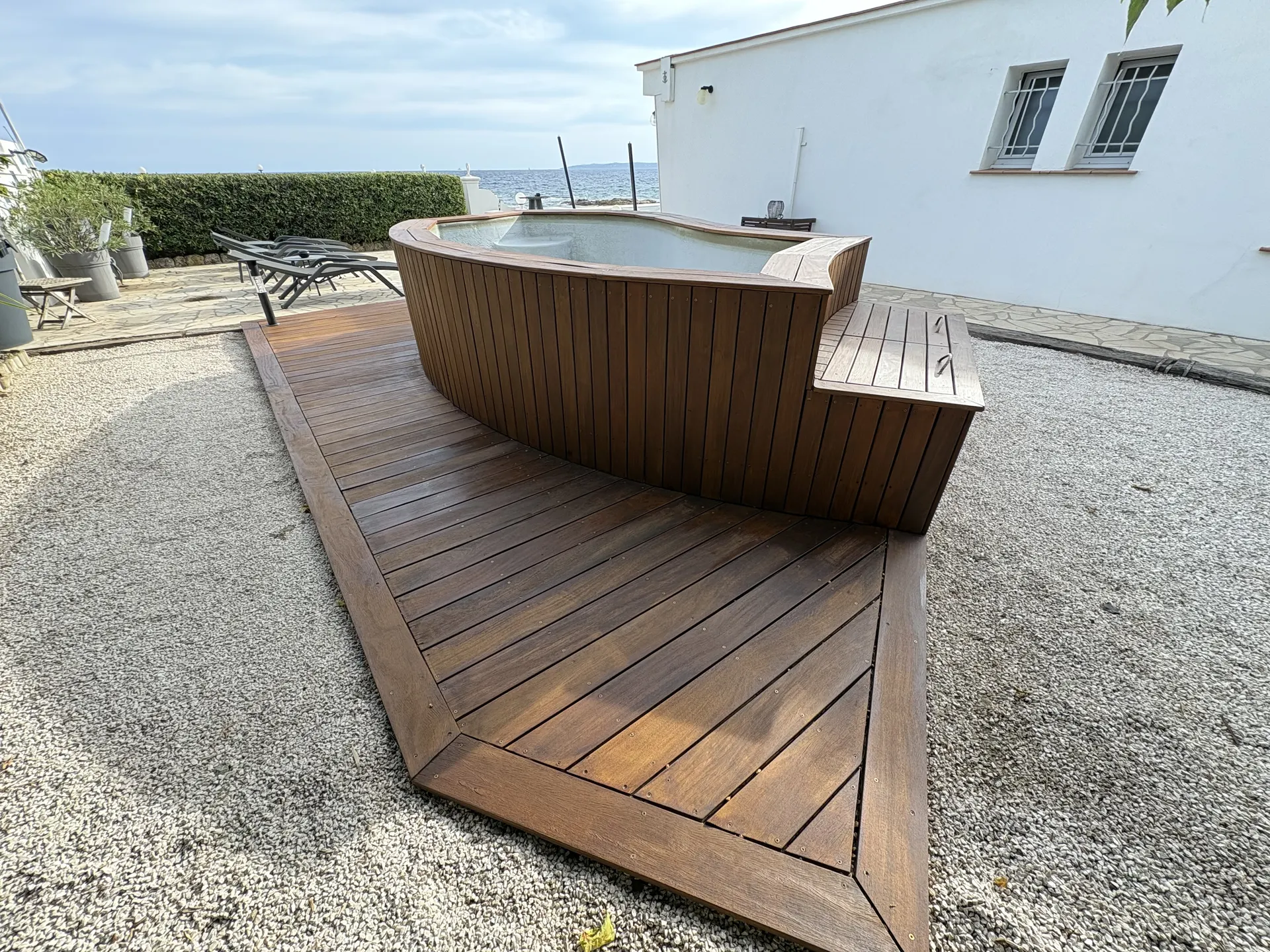 Terrasse en bois d'un spa et allée de gravier