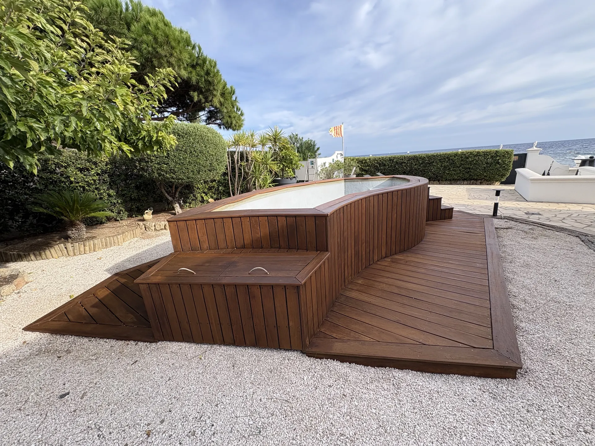 Deck en bois autour d'un spa avec vue sur la mer