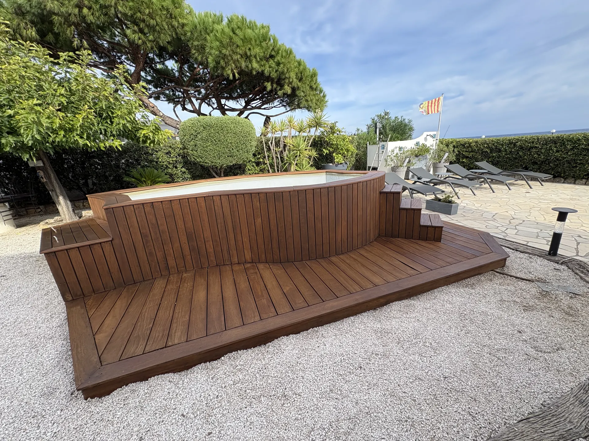 Deck en bois autour d'un spa avec vue sur la mer, rénové par Maison Veinage