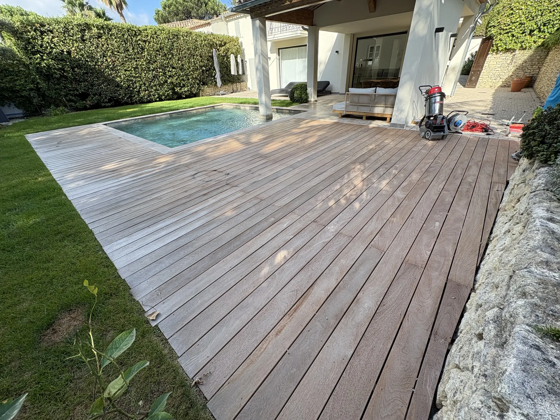 Terrasse en bois exotique autour de la piscine d'une villa, avant rénovation