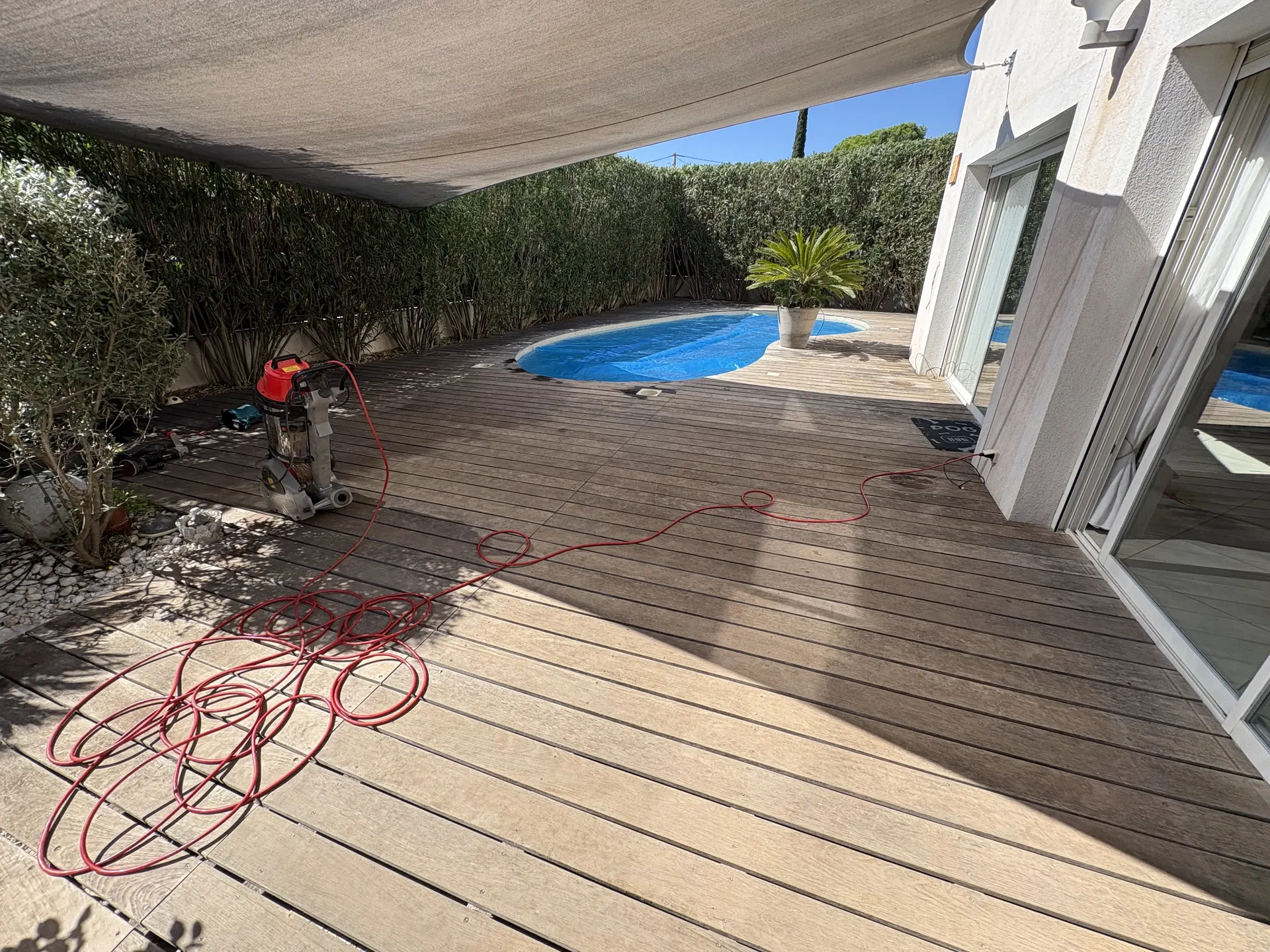 Terrasse en bois sous voile d'ombrage, avant rénovation
