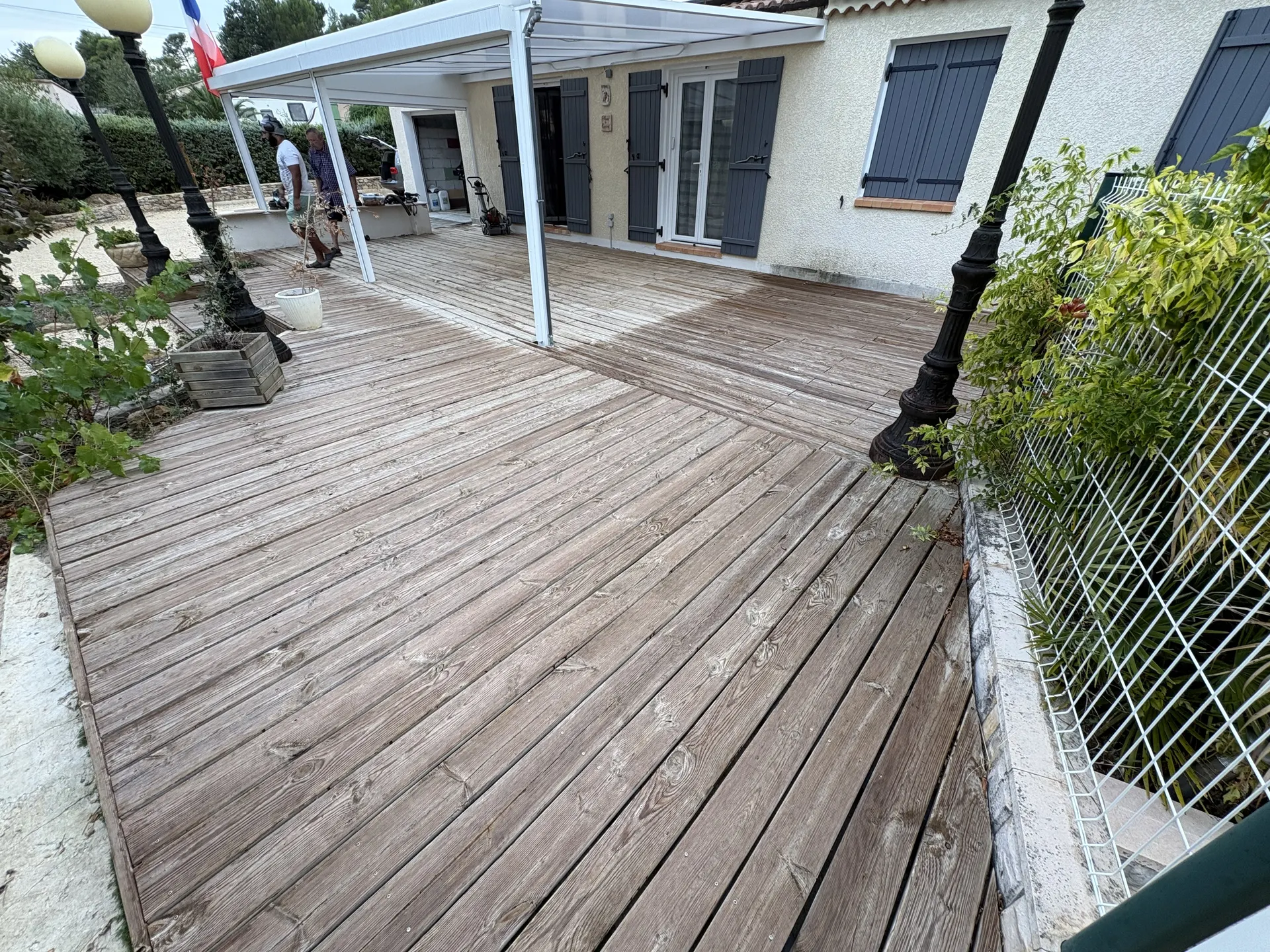 Terrasse en bois sous pergola blanche, avant rénovation