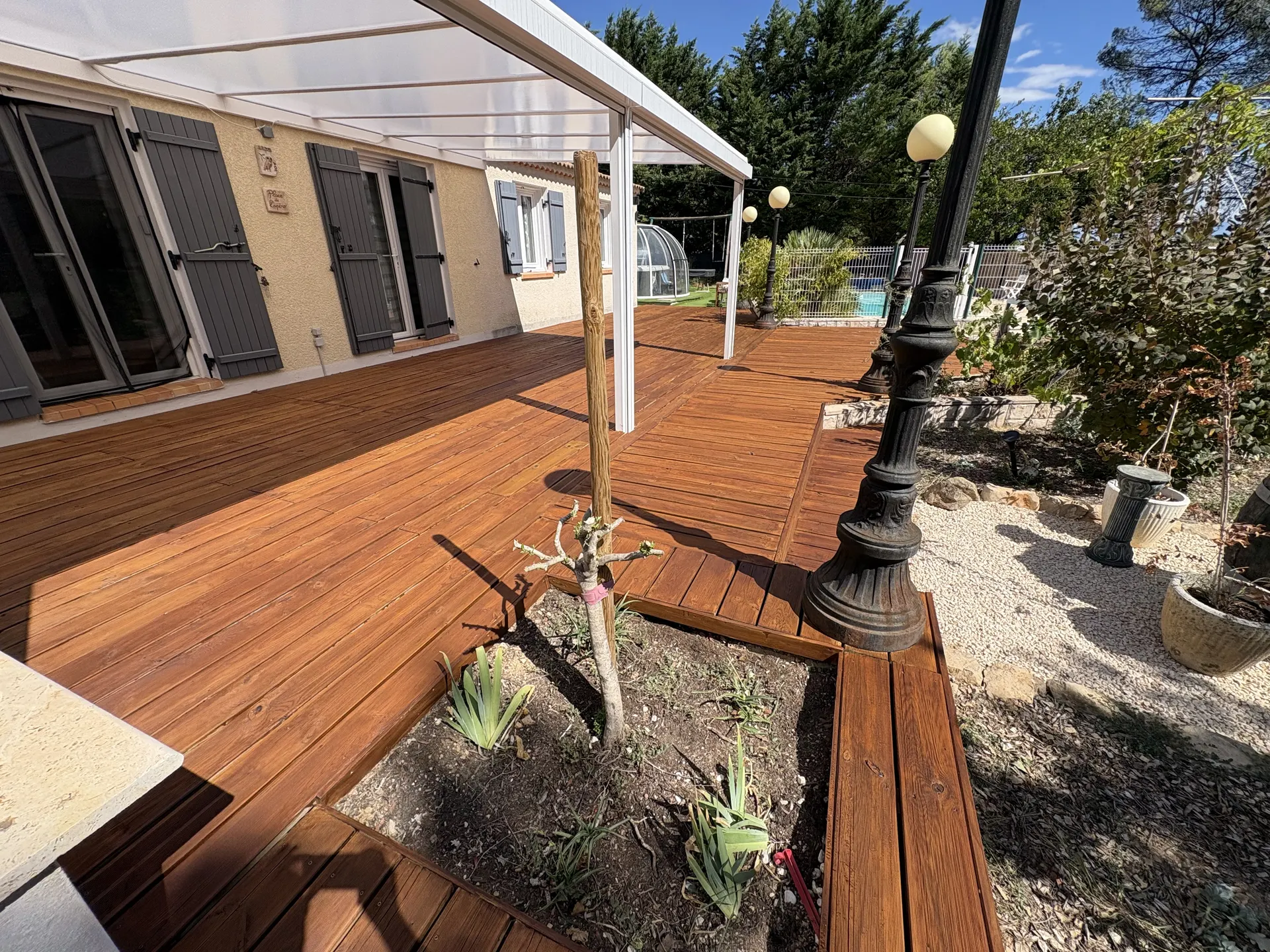 Terrasse en bois sous pergola blanche, après rénovation